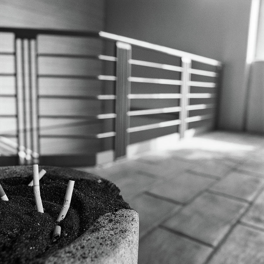 Black And White Photograph - Concrete Ashtray Close Up Cigarette Butts  by YoPedro