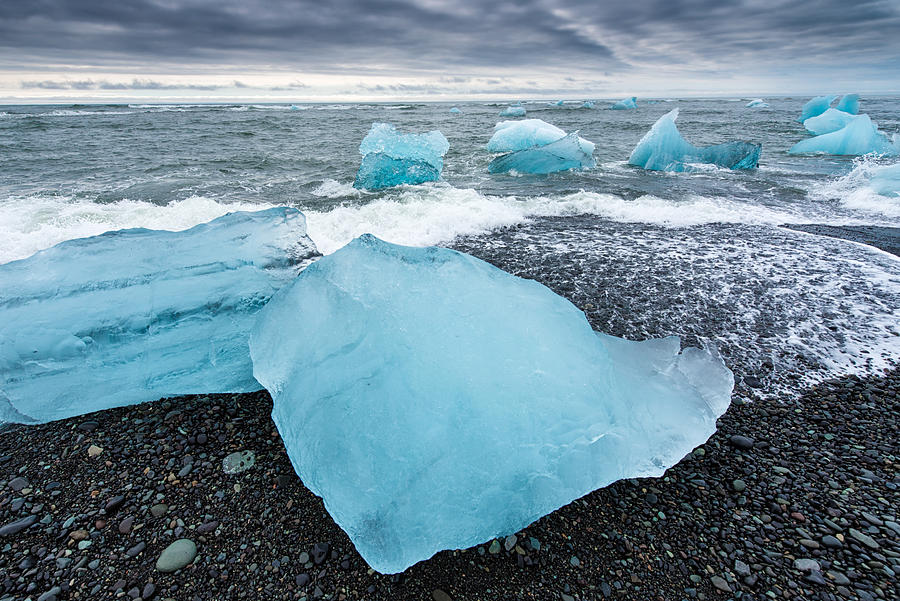 Cool blue glacier ice on black beach in Iceland Photograph by Matthias Hauser