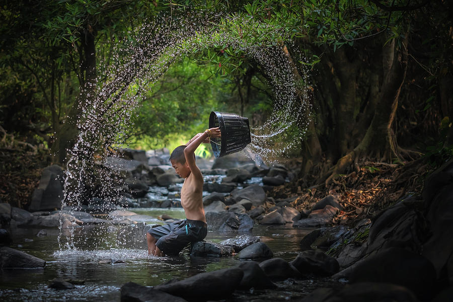 Fisherman throwing net by Visoot Uthairam