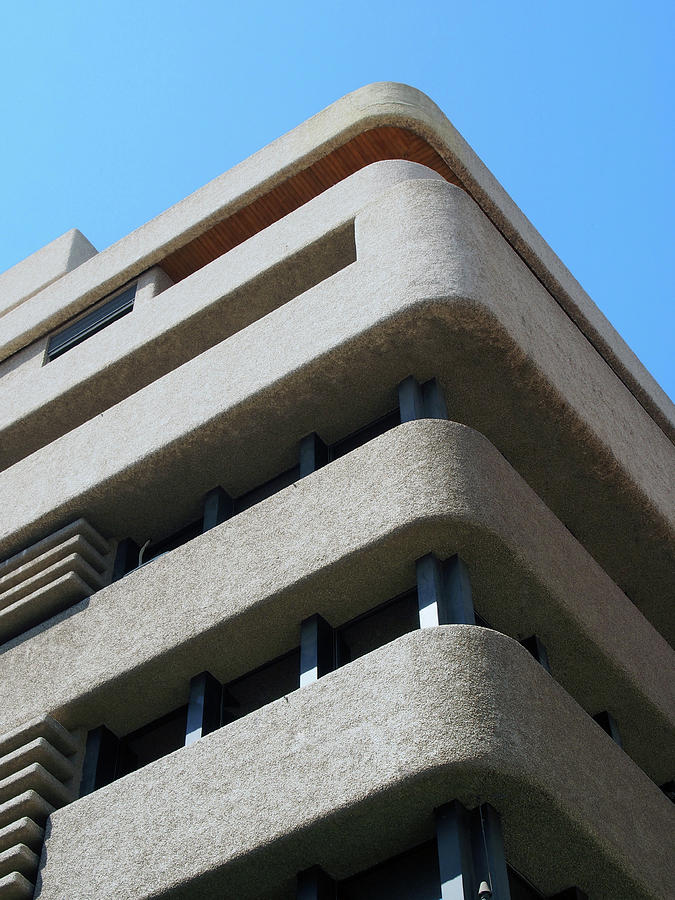 Corner Of A Brutalist Concrete Concrete Tower Block With Textured Rounded Corners Against A Blue Sky Photograph by Philip Openshaw