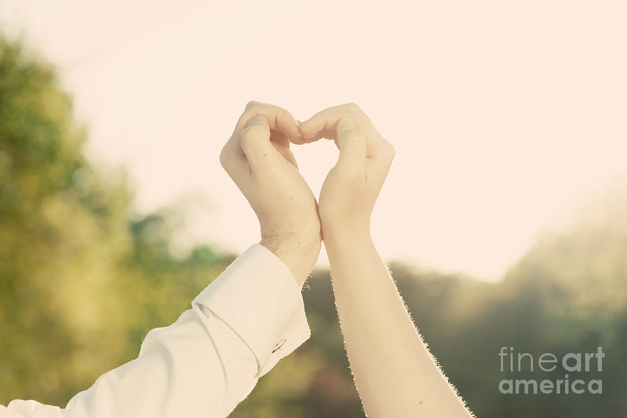 Couple in love making a heart shape with their hands outdoors Photograph by Michal Bednarek