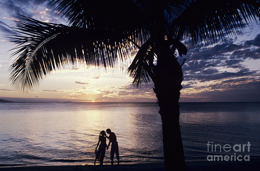 Couple silhouetted on beach Photograph by Larry Dale Gordon - Printscapes
