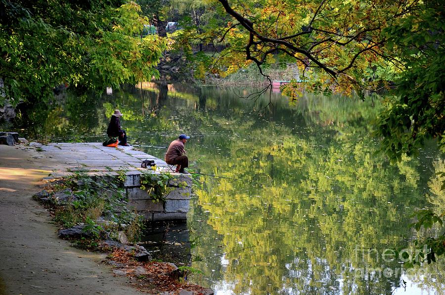 Couple sit quietly on jetty and fish at a lake outside Beijing China Photograph by Imran Ahmed