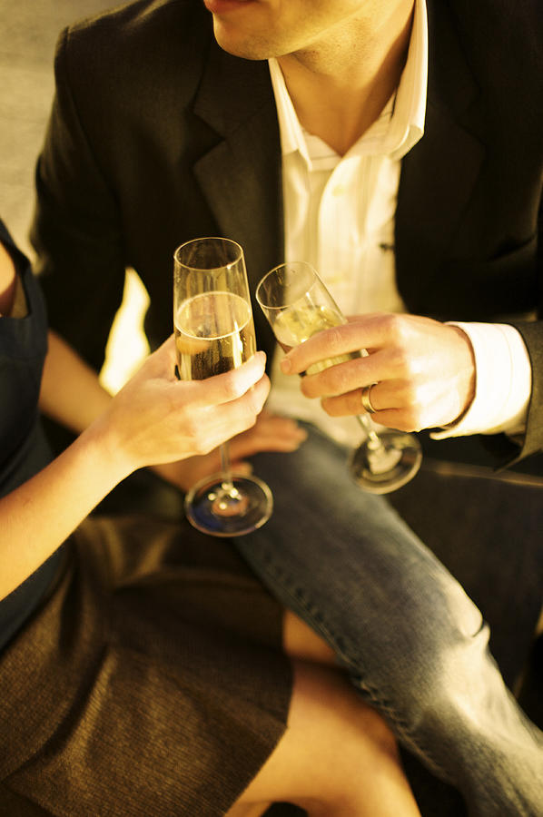 Flute Photograph - Couple Sitting, Clinking Champagne by Gillham Studios