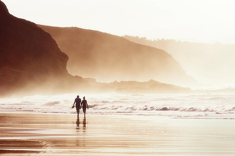 Couple Walking On Beach With Fog Photograph by Mikel Martinez de Osaba