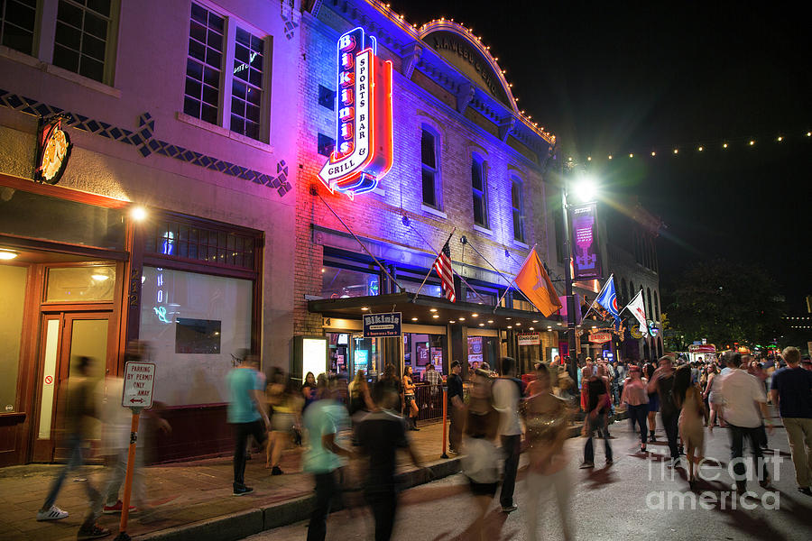 Beer Photograph - Crowds walk up and down past the bright neon lights of Austin fa by Dan Herron