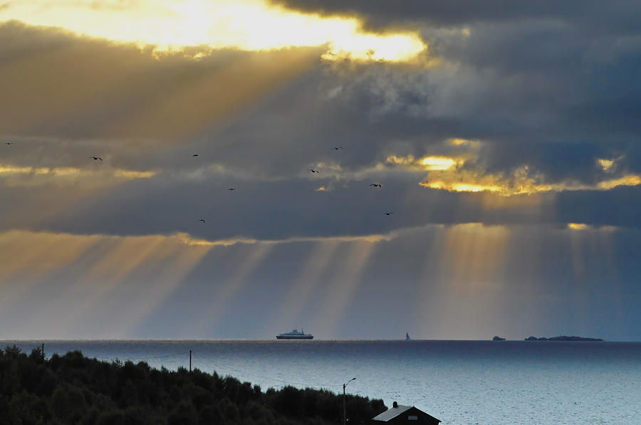 Cruise ship passing an island as sunrays shine through clouds Photograph by Ulrich Kunst And Bettina Scheidulin