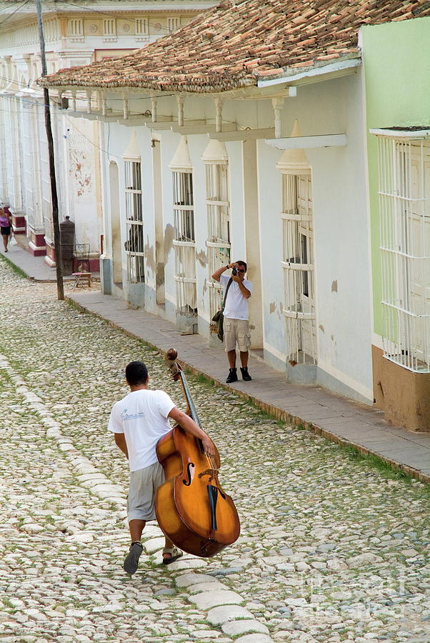 Cuban man carrying a cello Photograph by Sami Sarkis