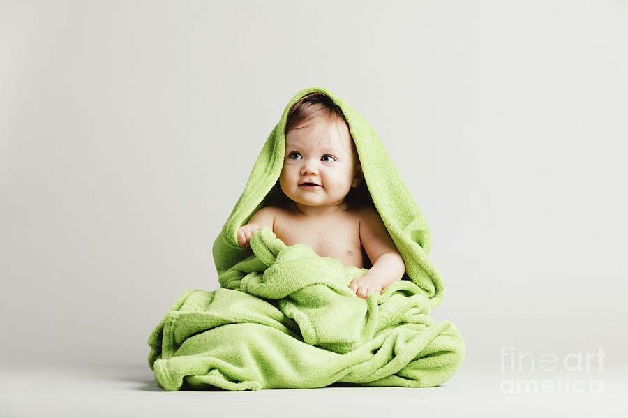 Cute baby girl covered in green blanket. Photograph by Michal Bednarek