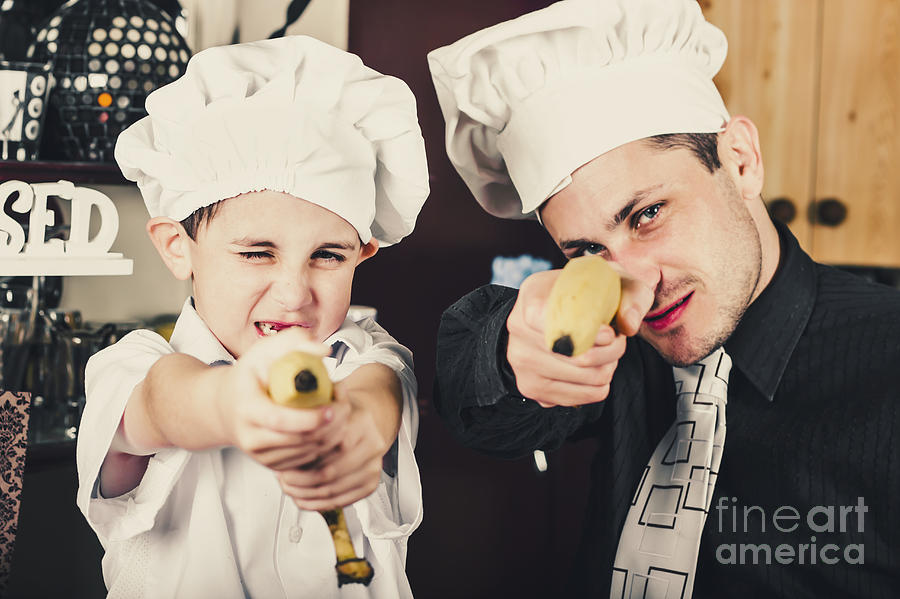Dad and son cooks shooting with bananas in kitchen Photograph by Jorgo Photography