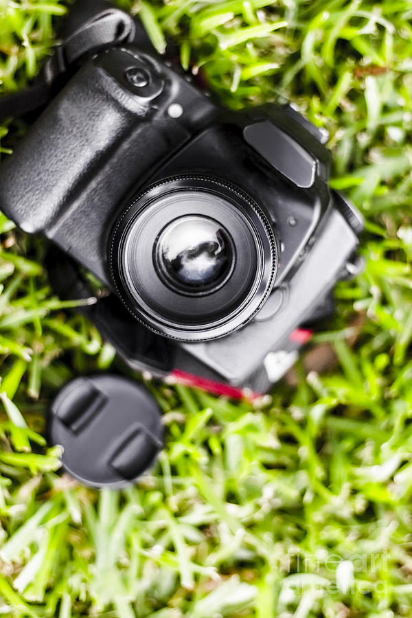 Digital SLR camera on green grassy field Photograph by Jorgo Photography