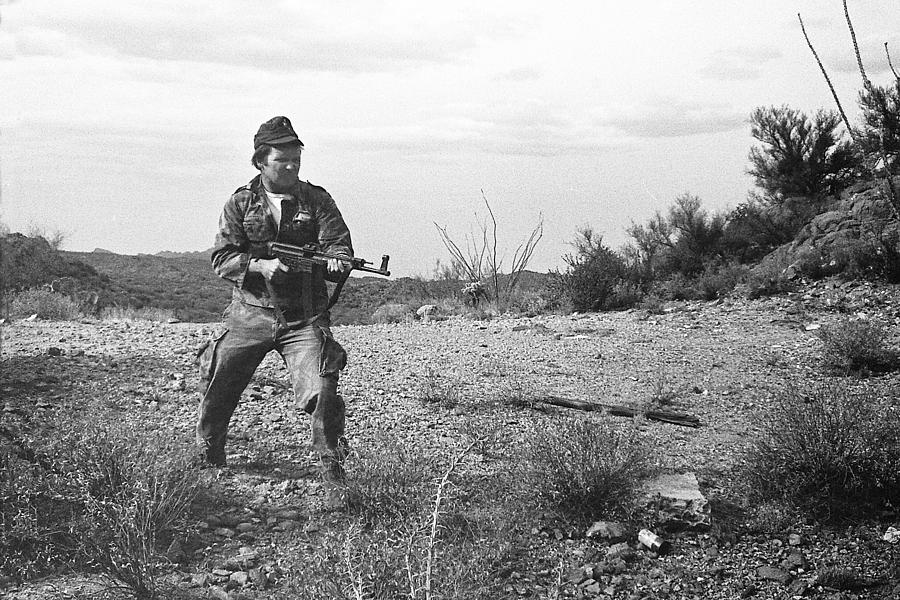 Distant view of Barry Sadler shooting another type  of his numerous  machine guns  Tucson AZ 1971 Photograph by David Lee Guss