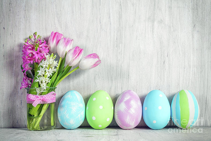 Easter eggs and a spring bouquet of tulips on a wooden table. Photograph by Michal Bednarek