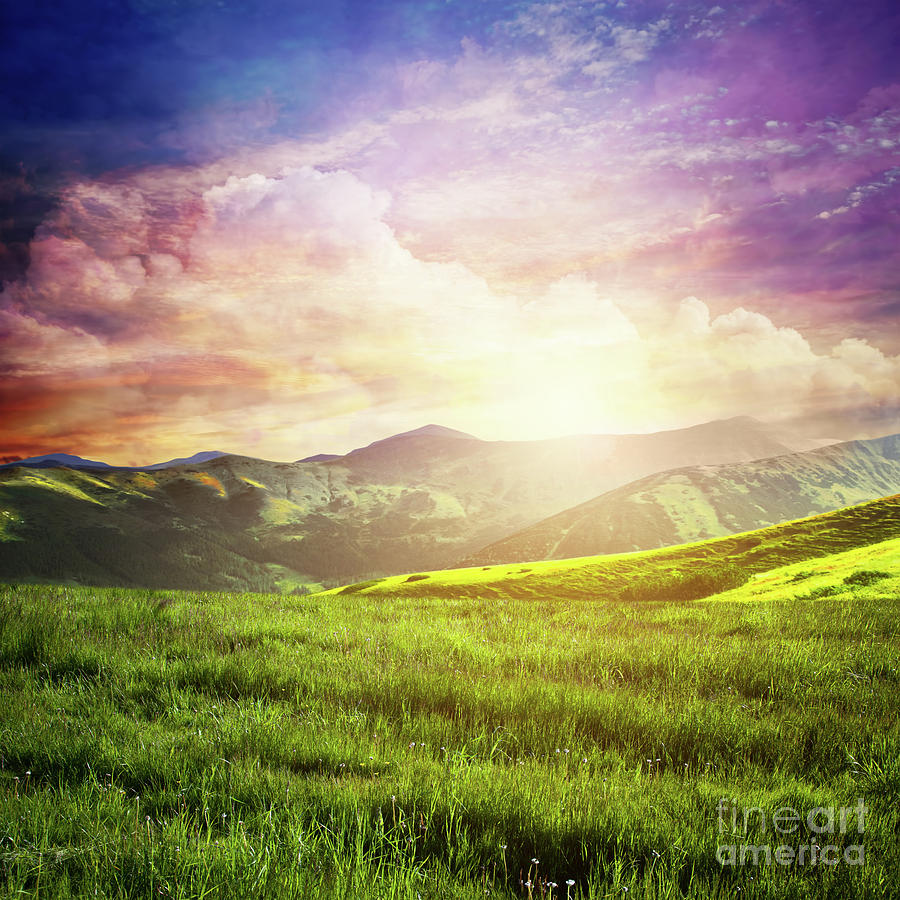 Fairtytale landscape with green grass, mountains, sunset fantastic sky. Photograph by Michal Bednarek