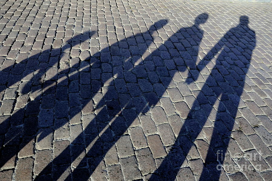 Family of four casting shadows on cobbled stone street Photograph by Sami Sarkis