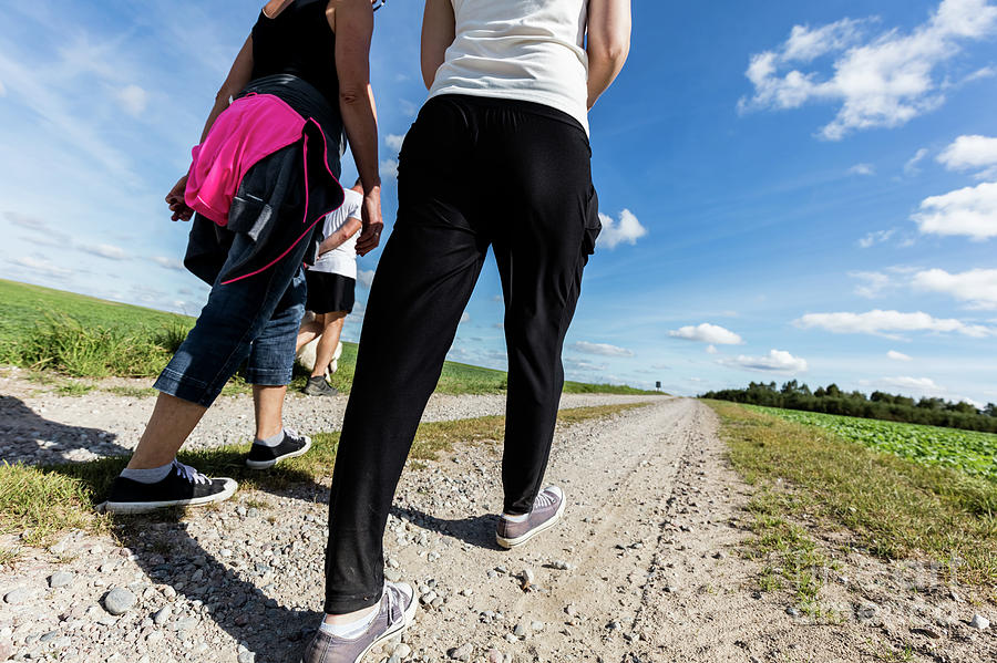 Family walk in countryside on a sunny day. Legs perspective Photograph by Michal Bednarek