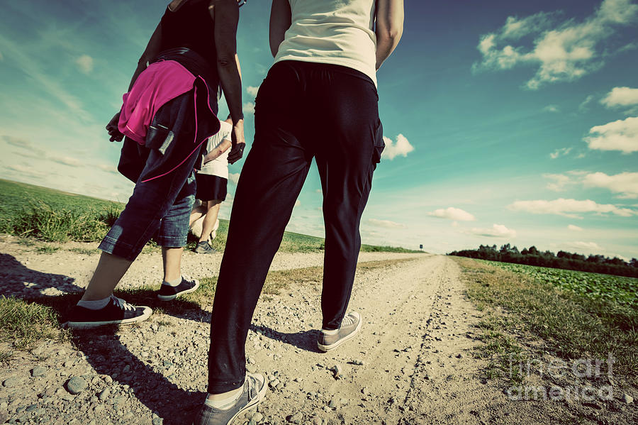 Family walk in countryside on a sunny day. Legs perspective. Vintage look Photograph by Michal Bednarek