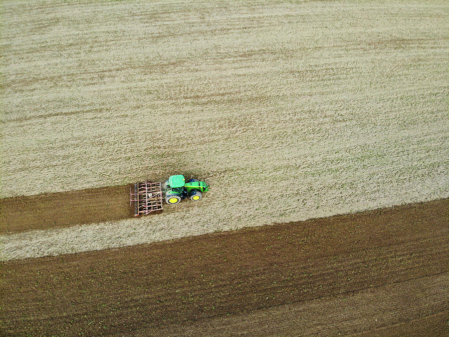 Farm Photograph - Farm tractor cutting furrows in field aerial image by Matthias Hauser