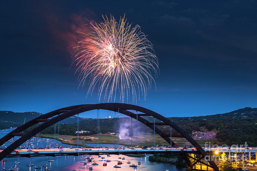 Fireworks light the night sky over the 360 Bridge on Lake Austin