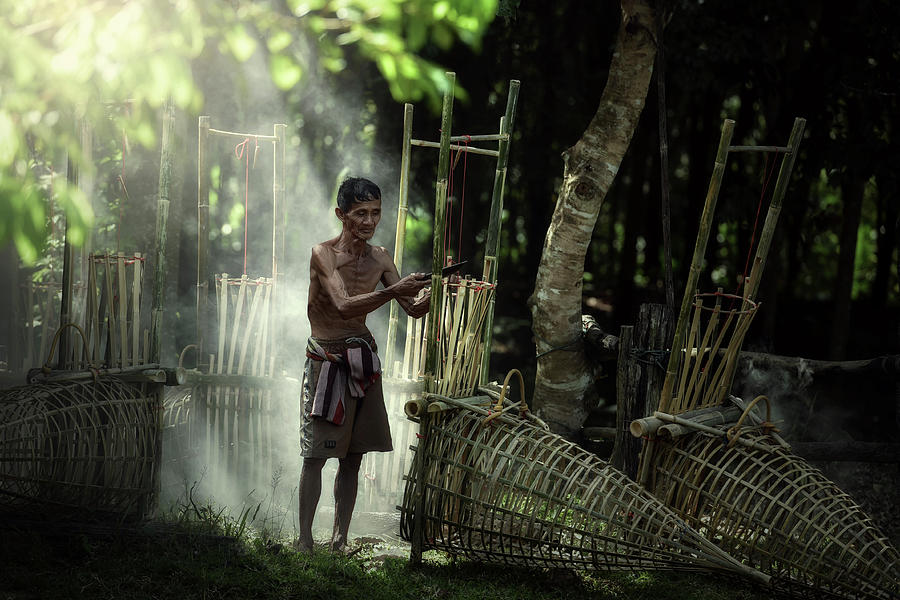 Fisherman builds an ancient fish trap in Thailand. by Somchai Sanvongchaiya