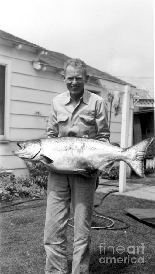 Black And White Photograph - Fisherman holding a King Salmon by Monterey County Historical Society