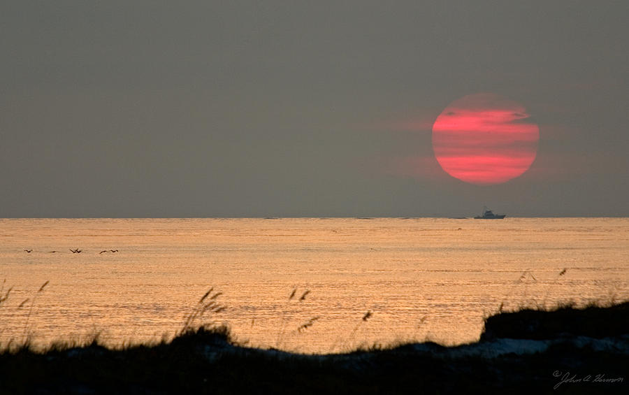 Sunset Photograph - Fishing Boat Under Setting Sun by John Harmon