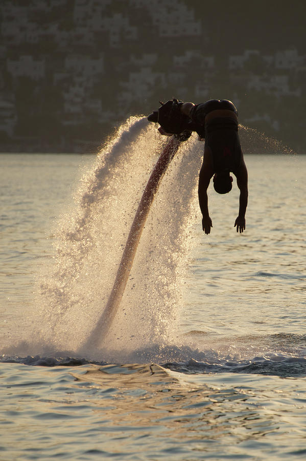 Turkey Photograph - Flyboarder silhouetted in dive towards evening sea by Ndp