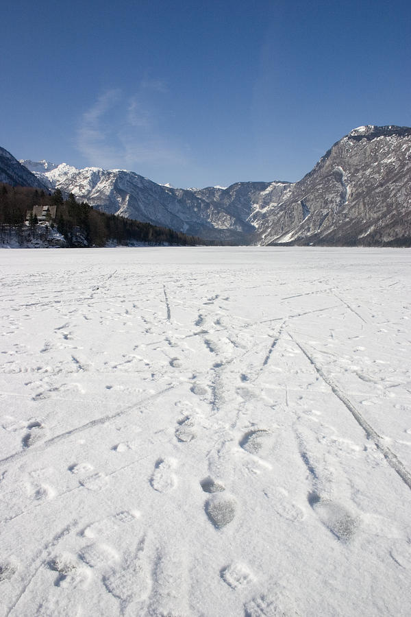 Footprints on a frozen lake Photograph by Ian Middleton