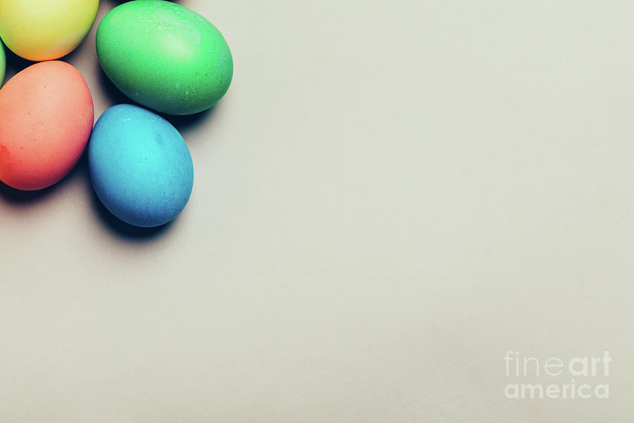 Four colored eggs in a corner on creamy background Photograph by Michal Bednarek