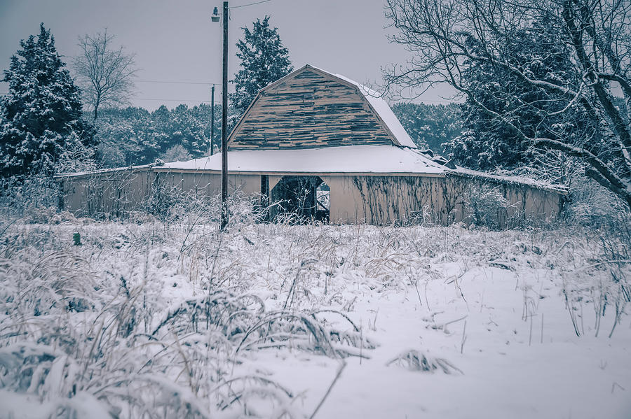 Fresh snow sits on the ground around an old barn Photograph by Alex Grichenko