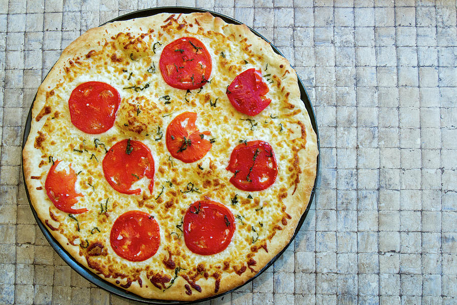 Fresh whole margarita pizza on tile Photograph by Karen Foley