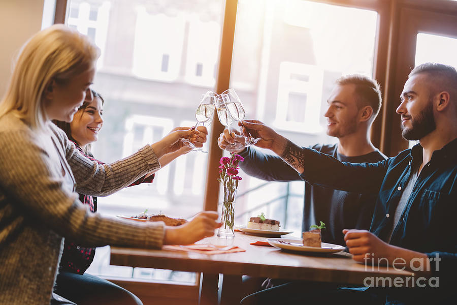 Toast Photograph - Friends toasting in a restaurant, celebrating. by Michal Bednarek