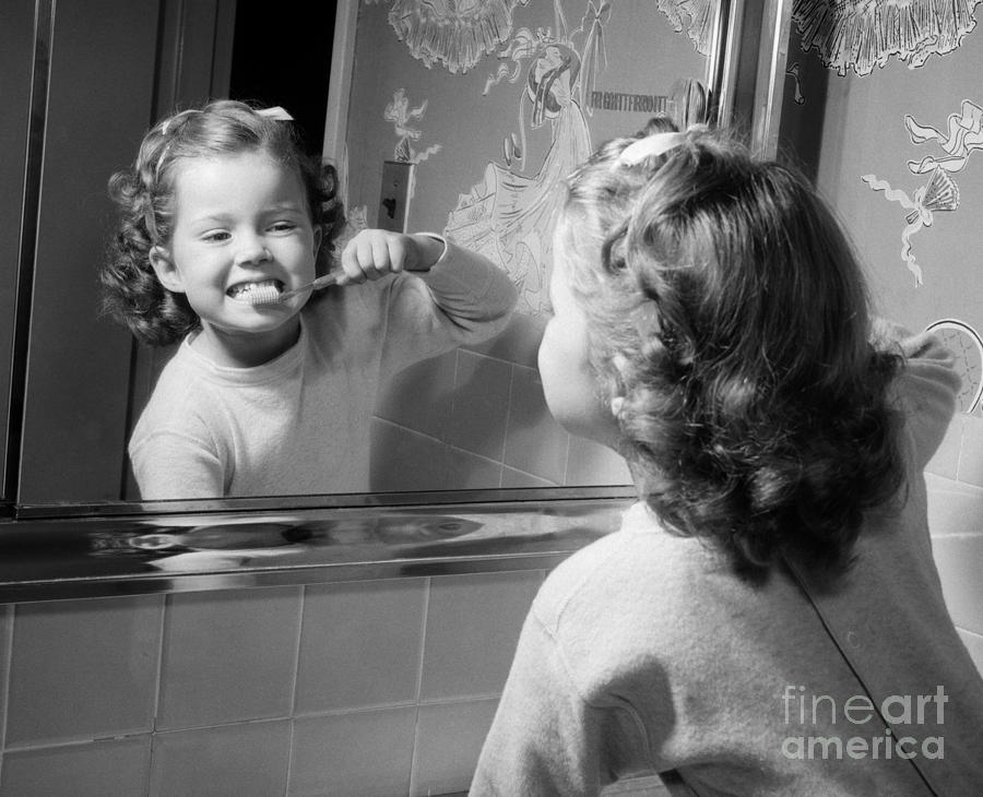 Vintage Photograph - Girl Brushing Teeth In Mirror, C.1950s by Debrocke ClassicStock