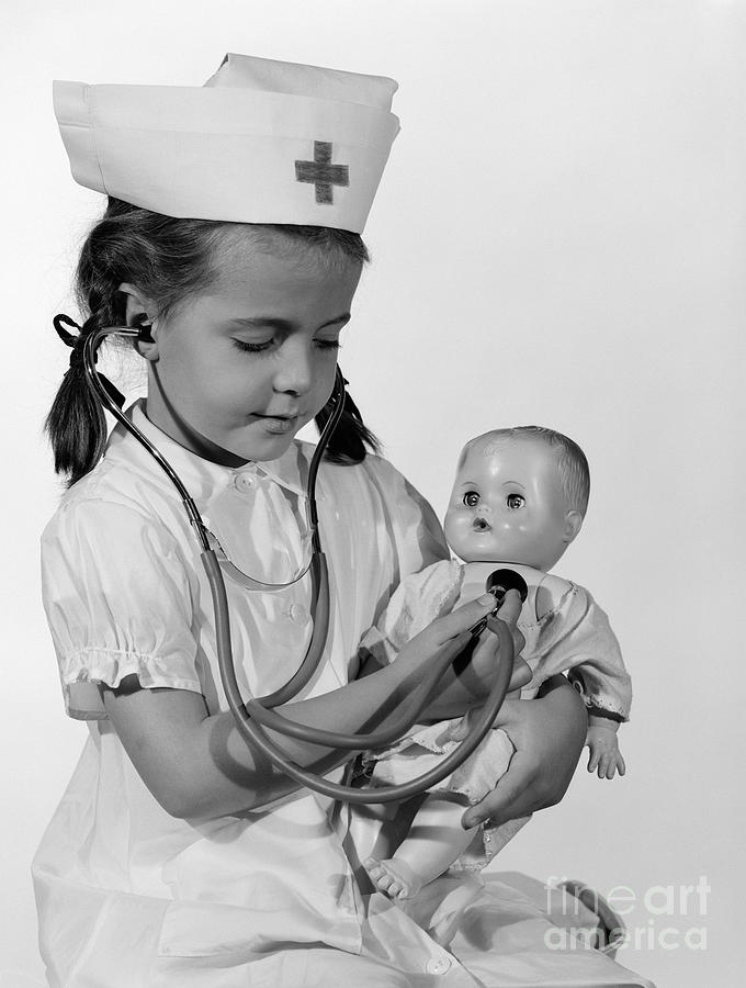 Girl Playing Nurse With Doll, C.1960s Photograph by H Armstrong Roberts ClassicStock