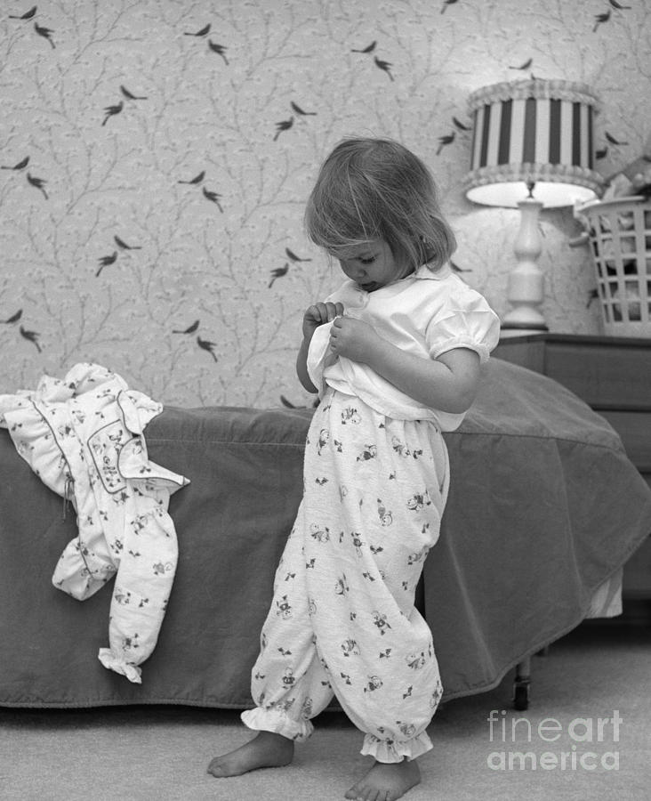 Girl Putting On Pajamas, C.1960s Photograph by H. Armstrong