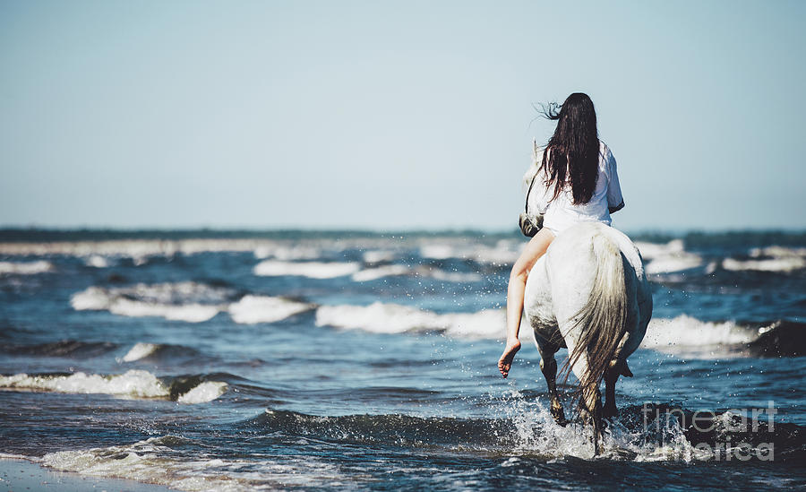 Girl riding on the white stallion in the sea. Photograph by Michal Bednarek