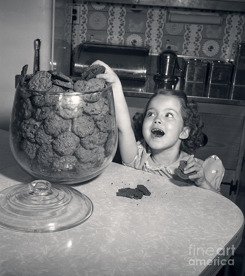 Girl With Hand In Cookie Jar, C.1950s Photograph by Debrocke/ClassicStock