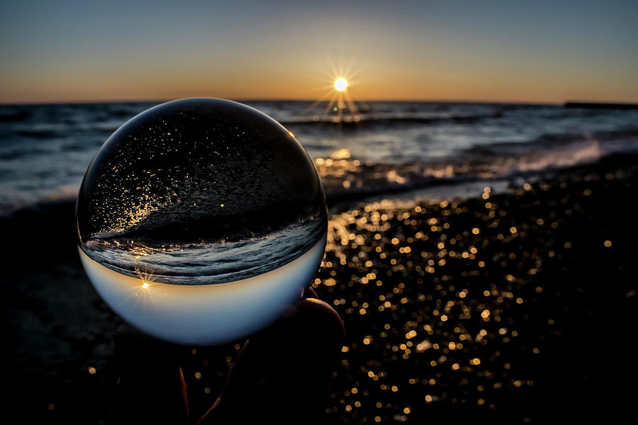 Glass ball on the beach at sunrise by Sven Brogren