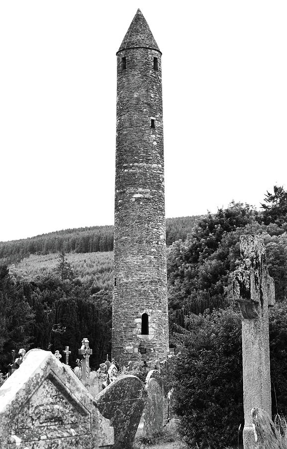 Glendalough Round Tower Rising Above Irish Graveyard County Wicklow Ireland Black and White Photograph by Shawn OBrien