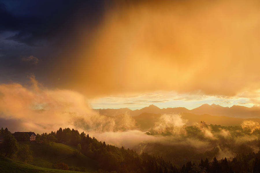 Golden clouds and fog at sunrise in the mountains of Kamnik Savi ...