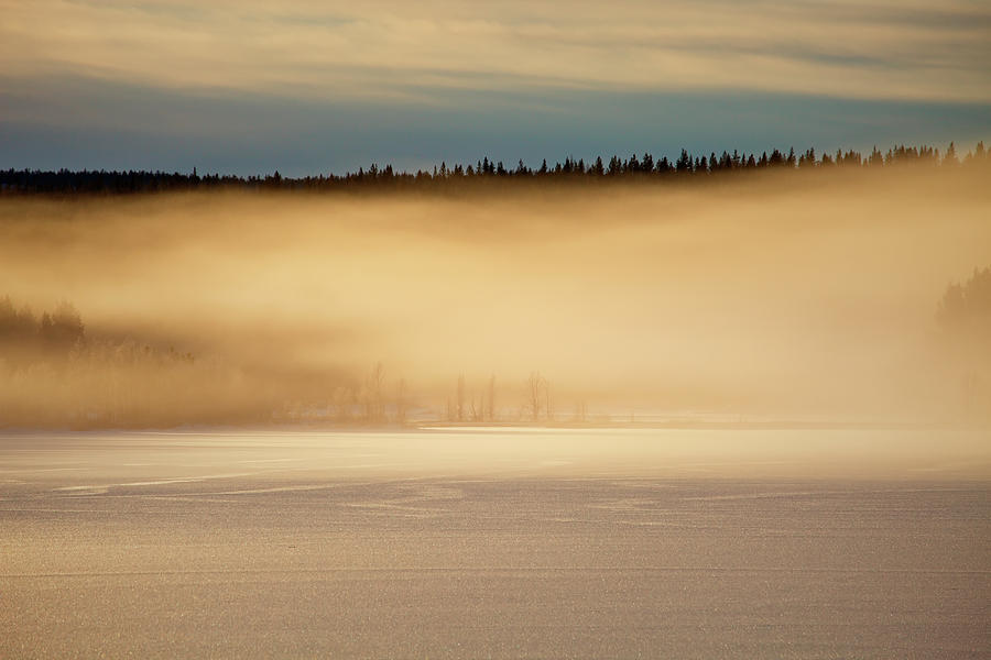 Golden Mists Are Rising From An Ice Covered Lake At Sunset Photograph