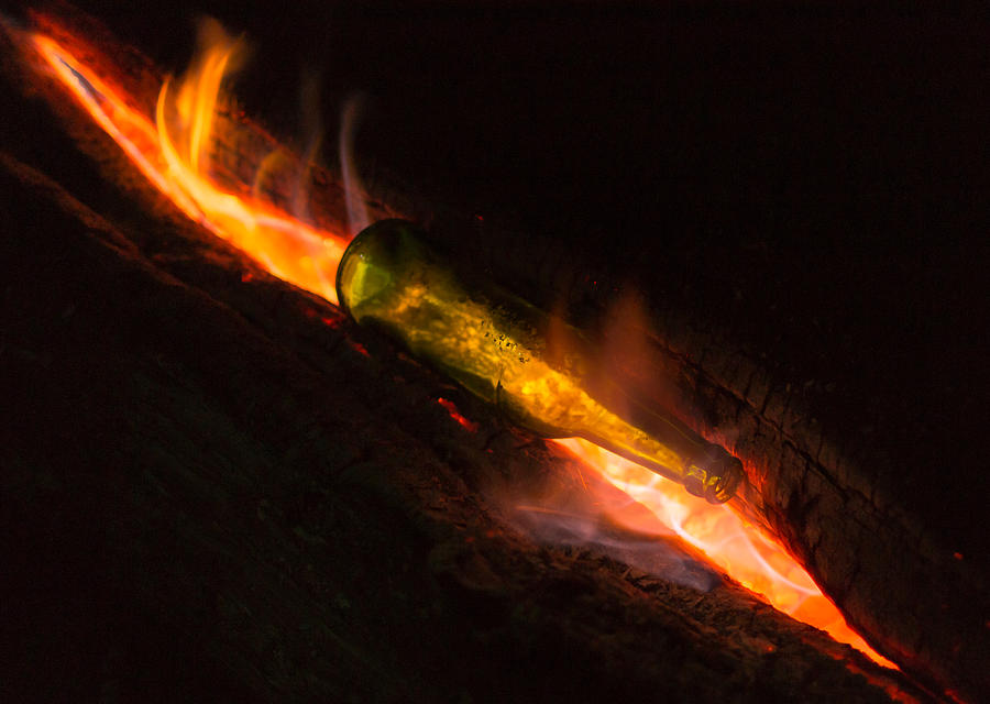 Green Glass Bottle and Campfire Photograph by John Williams
