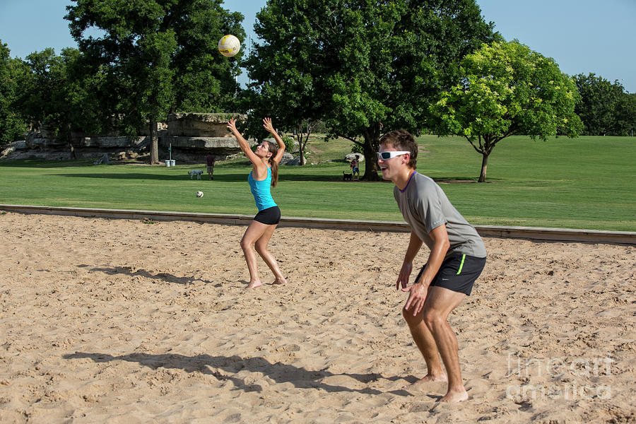 Tree Photograph - Group of friends playing volleyball on the Zilker Park sand volleyball courts female returning the serve ball in play by Dan Herron