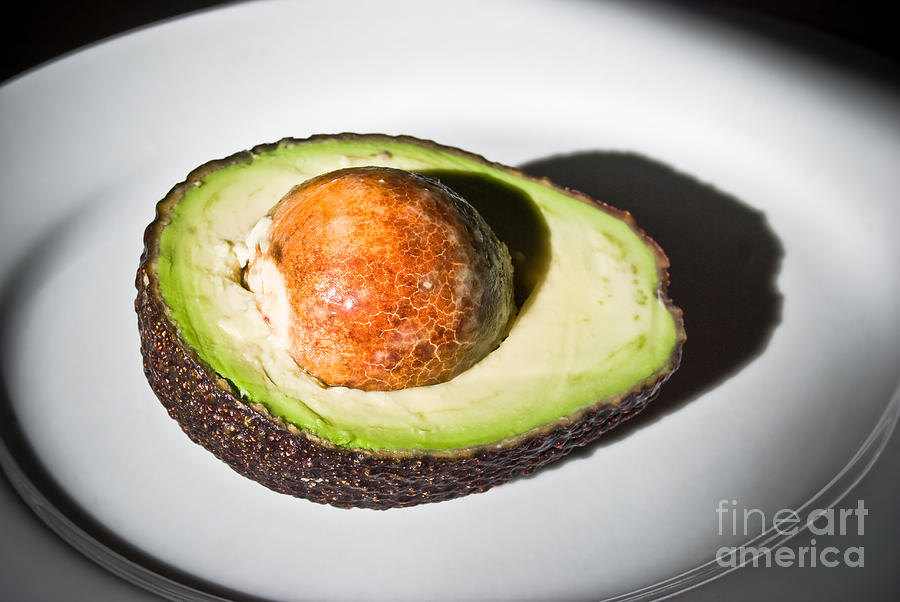 Half Avocado on white plate Photograph by Yurix Sardinelly