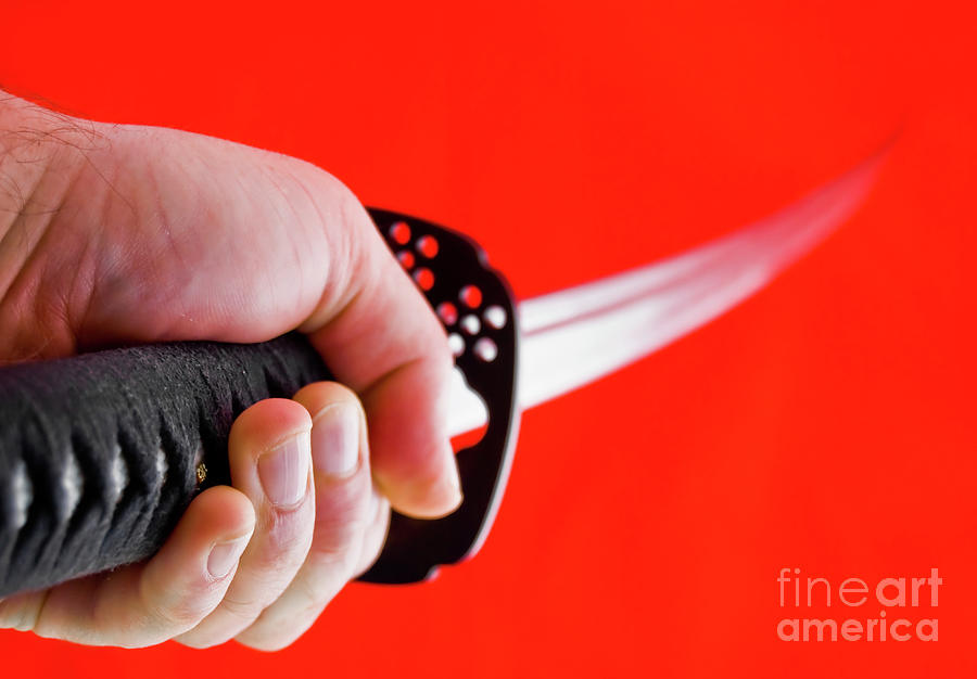 Hand holding Japanese sword - katana Photograph by Yurix Sardinelly