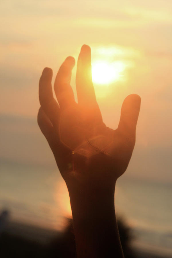 Hand reaching fore the sun Photograph by Emanuel Tanjala