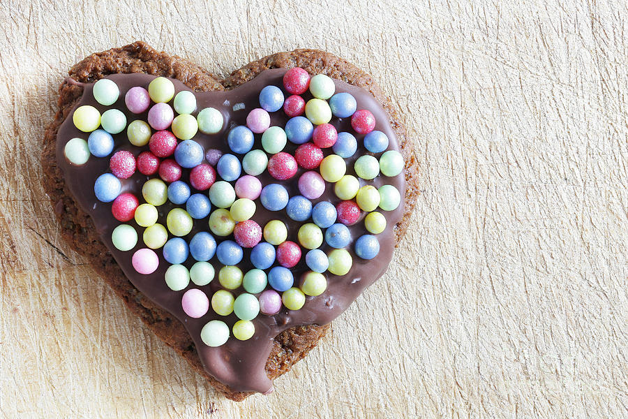 Christmas Photograph - Handmade gingerbread heart decorated with colorful sugar pearls by Michal Bednarek