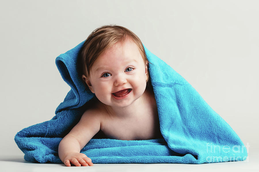 Happy child covered in blanket laying on her tummy Photograph by Michal Bednarek