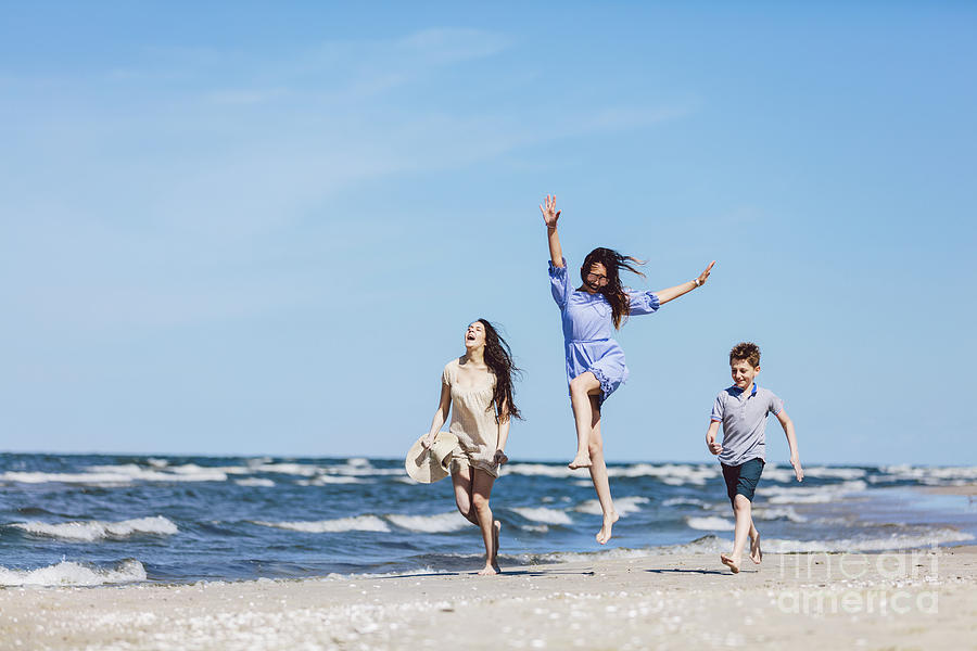Happy family having a good time on the beach. Photograph by Michal Bednarek