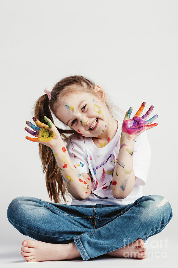 Happy girl covered in paint sitting on the floor. Photograph by Michal Bednarek